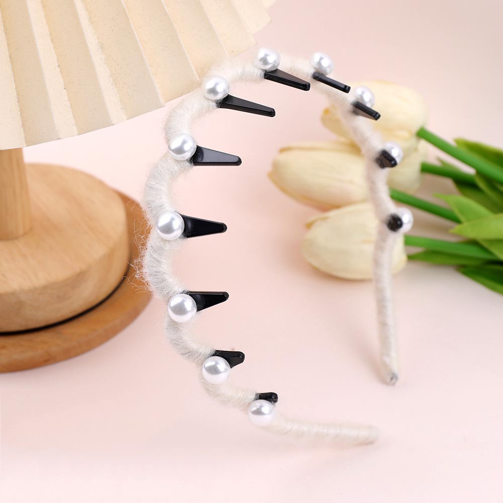 Hairband with black spikes and pearls on a light pink background with tulips.