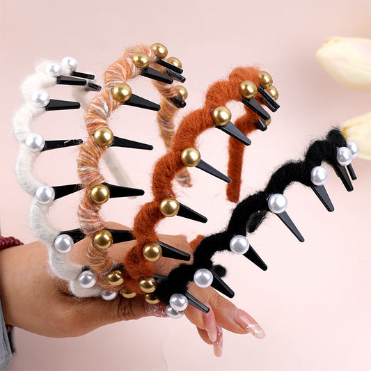 Set of hair clips with decorative elements held by a person against a light pink background